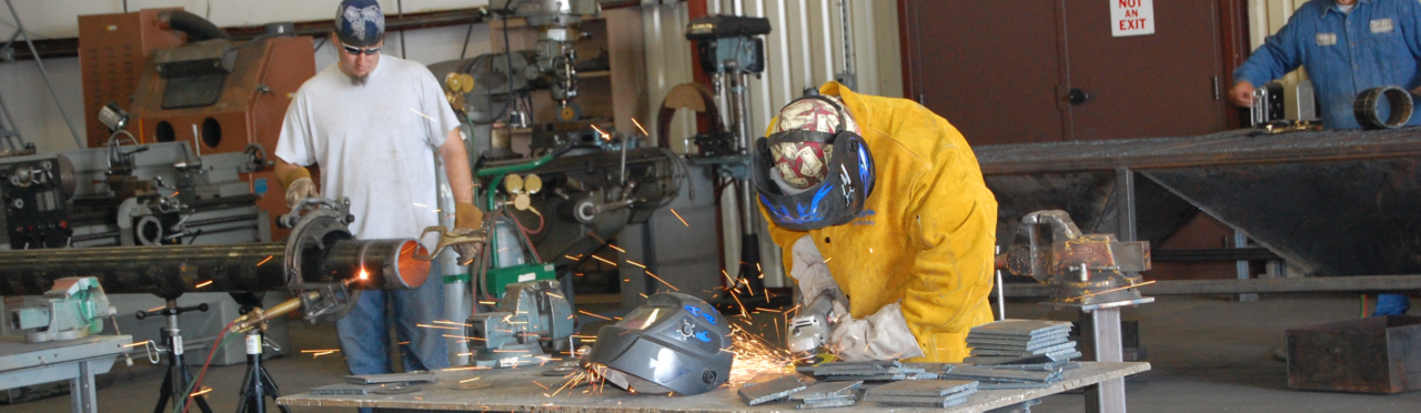 Two men welding in a shop