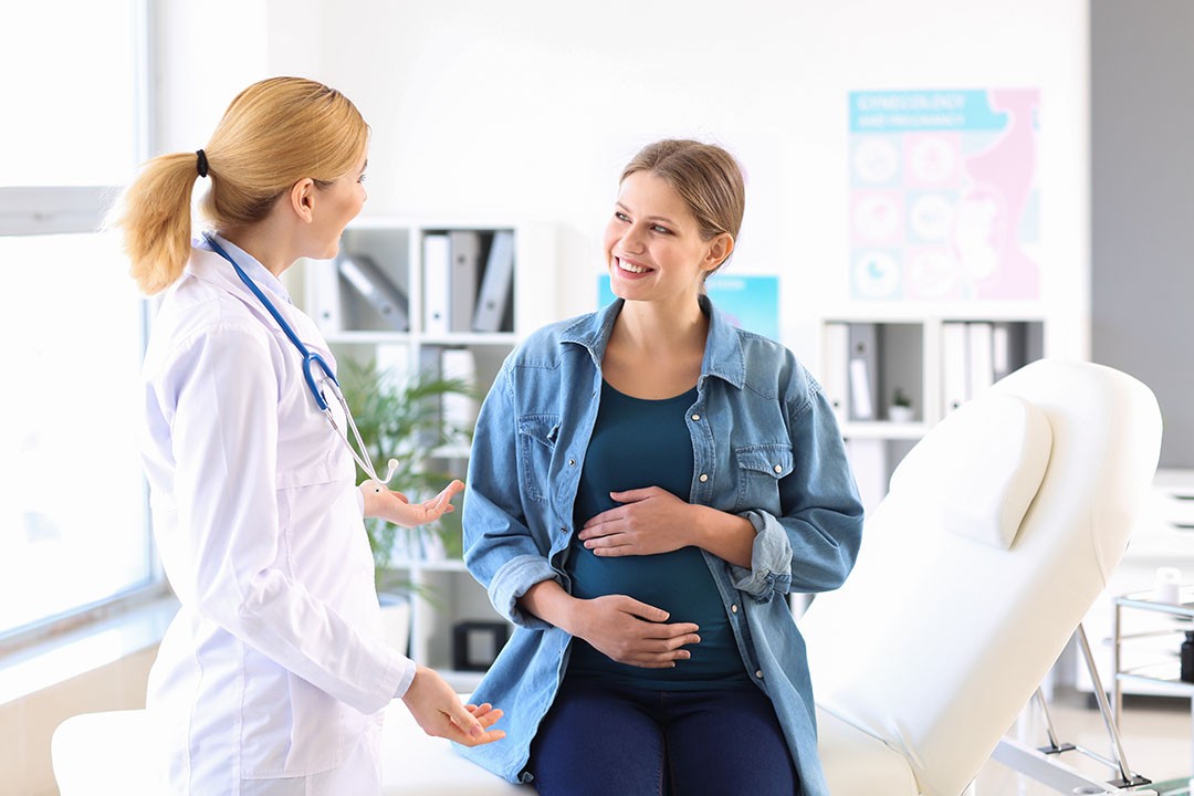 Young pregnant woman visiting her gynecologist in clinic