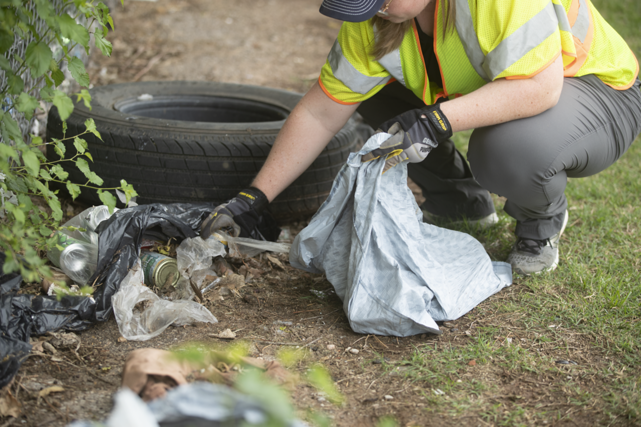 Woman picking up trash off of the ground