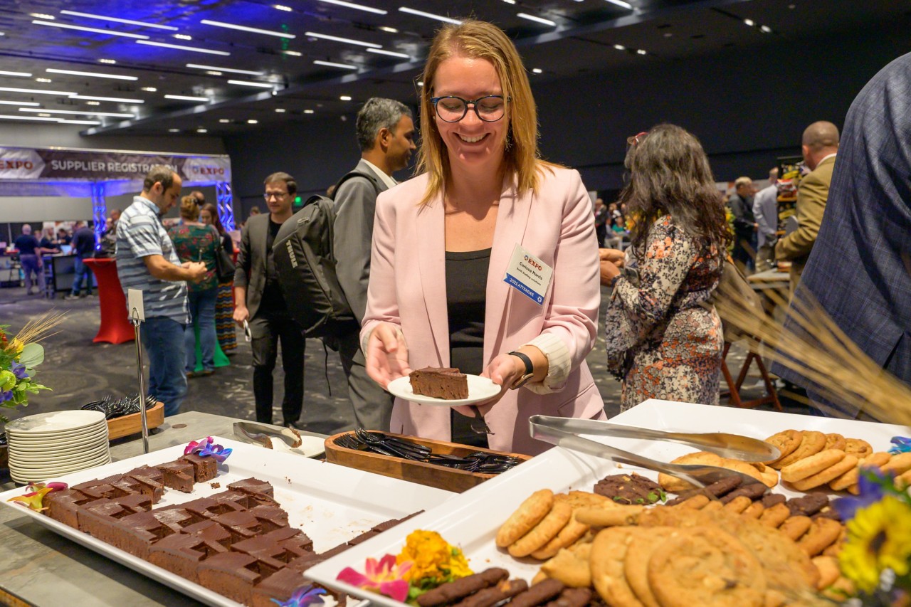 2023 attendee smiling with an Oklahoma-shaped brownie on a plate.