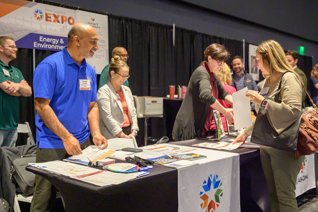 Cabinet staff engages with attendee at Energy and Environment booth.