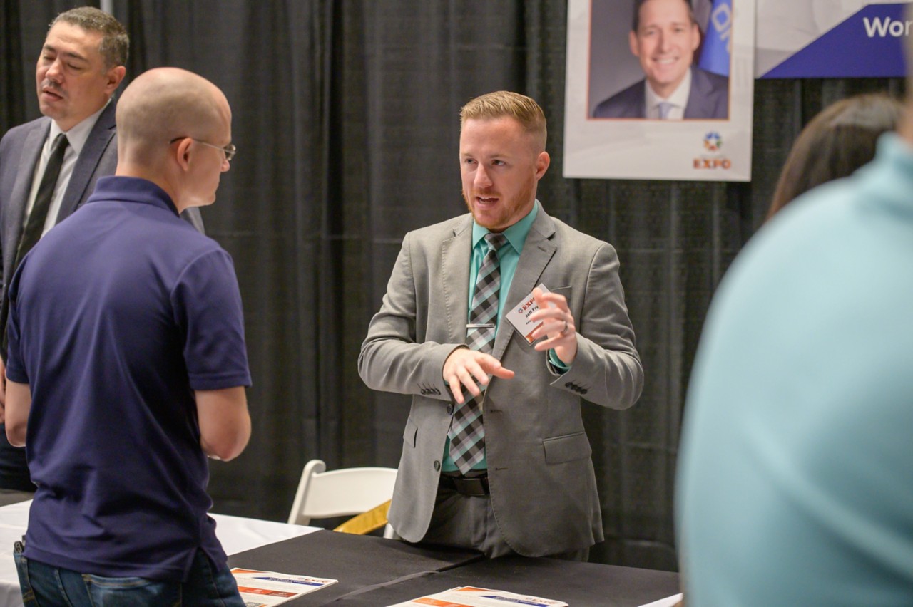 Jeff Fryer talking toan attendee at the Workforce and Economic Development cabinet booth.