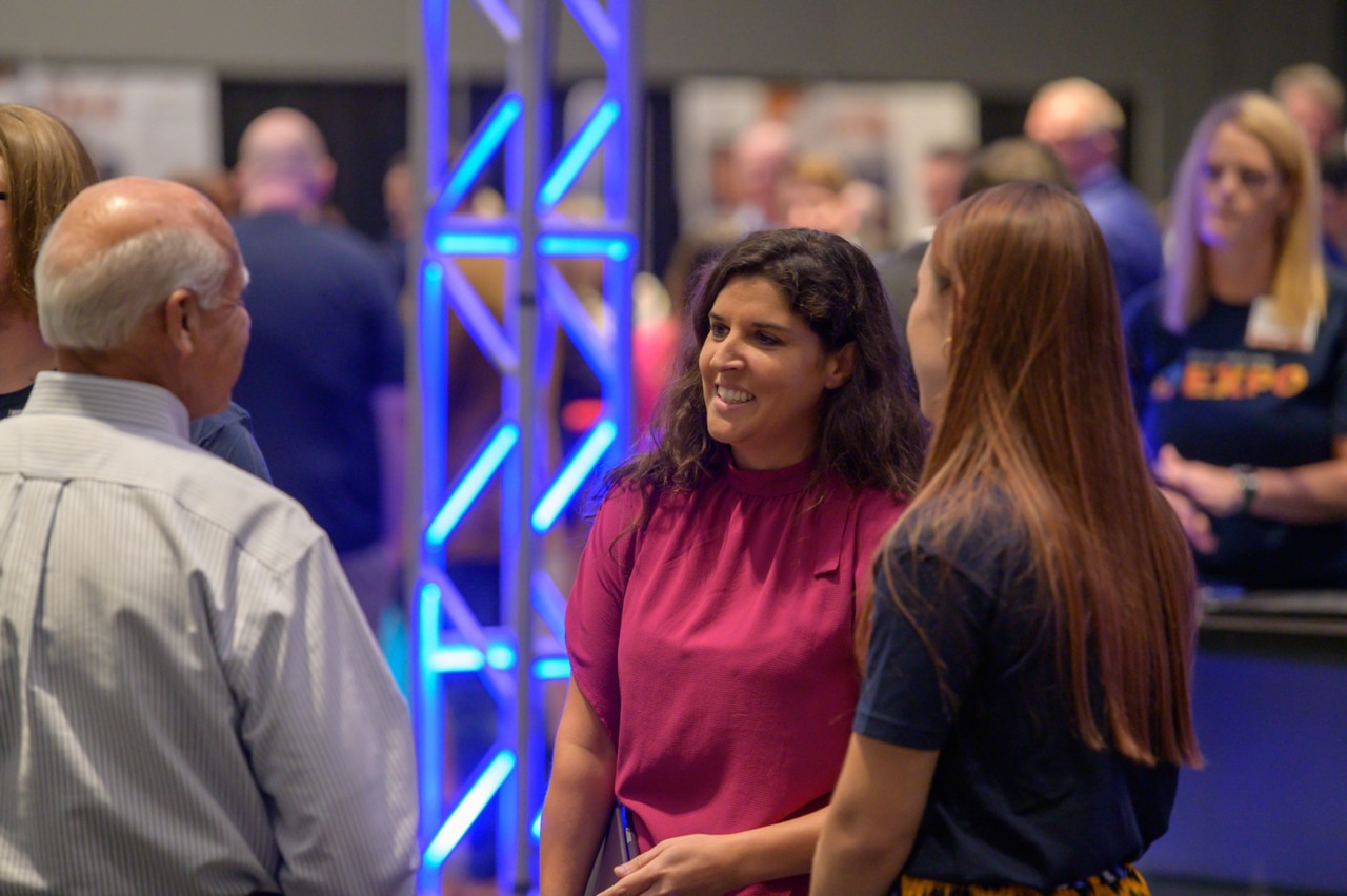 Charles Ortega with Kay Thompson and Christa Helfrey in front of the Supplier Registration booth.