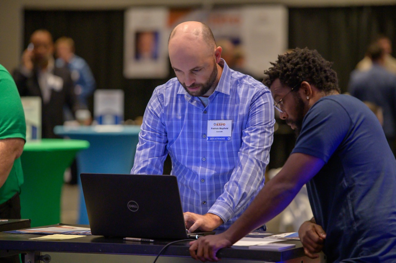 OMES Central Purchasing staff helping an attendee sign up as a state bidder on a laptop.