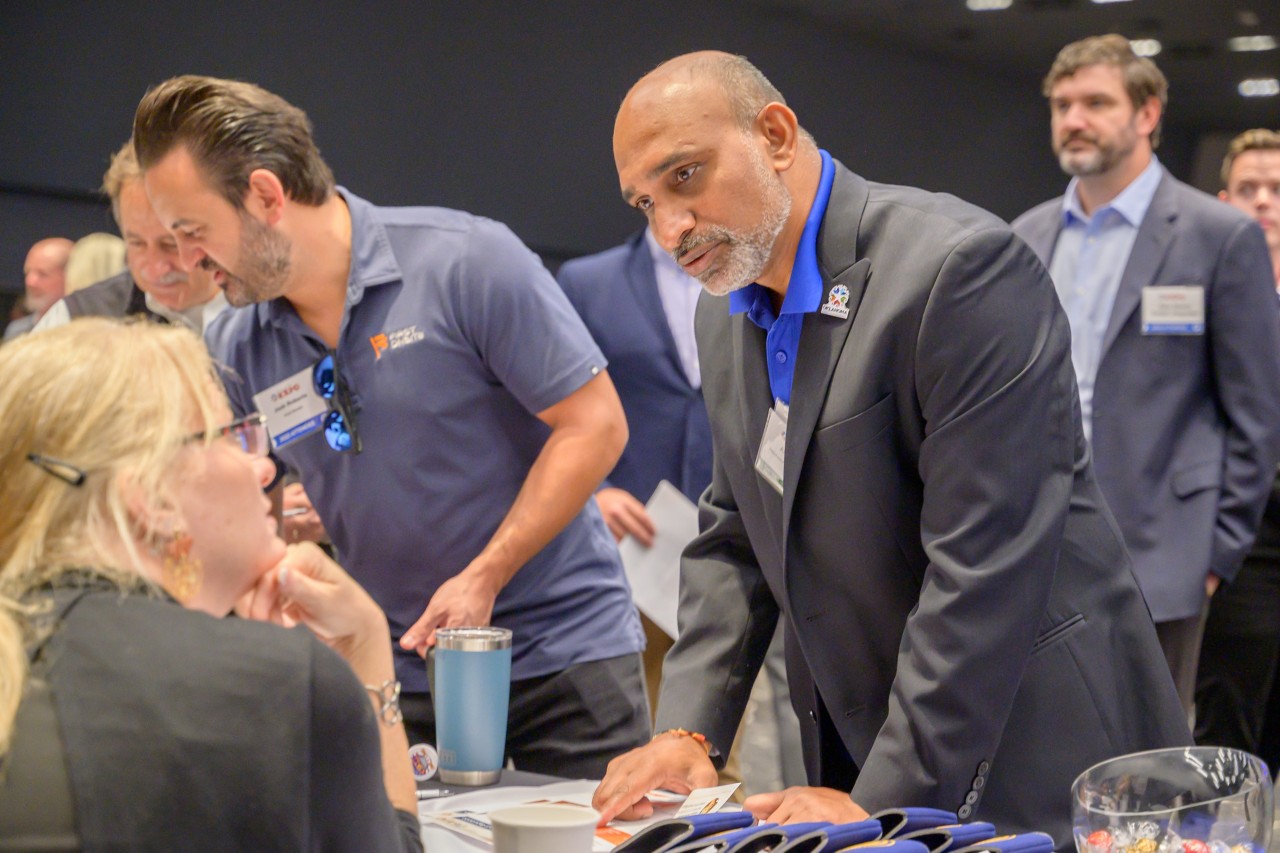 People talking at the Licensing and Regulation booth.