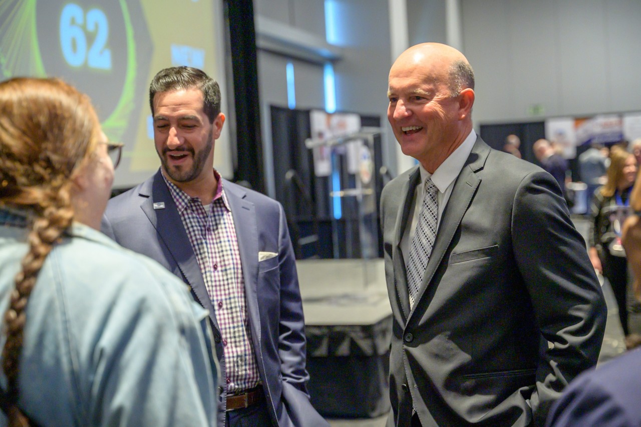 State COO John Suter smiling while talking to group after his speech.