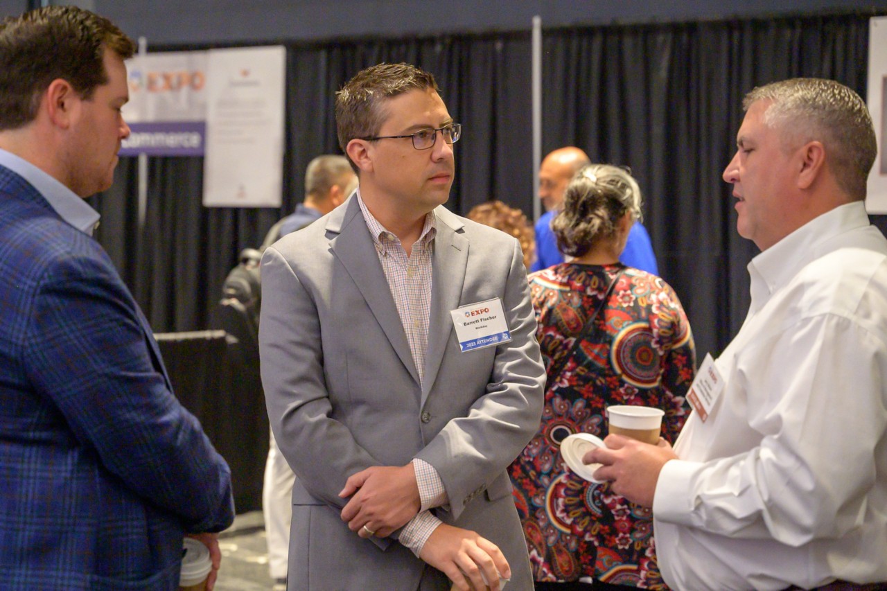 Two technology attendees talking to State Chief Transformation Officer Jerry Moore.