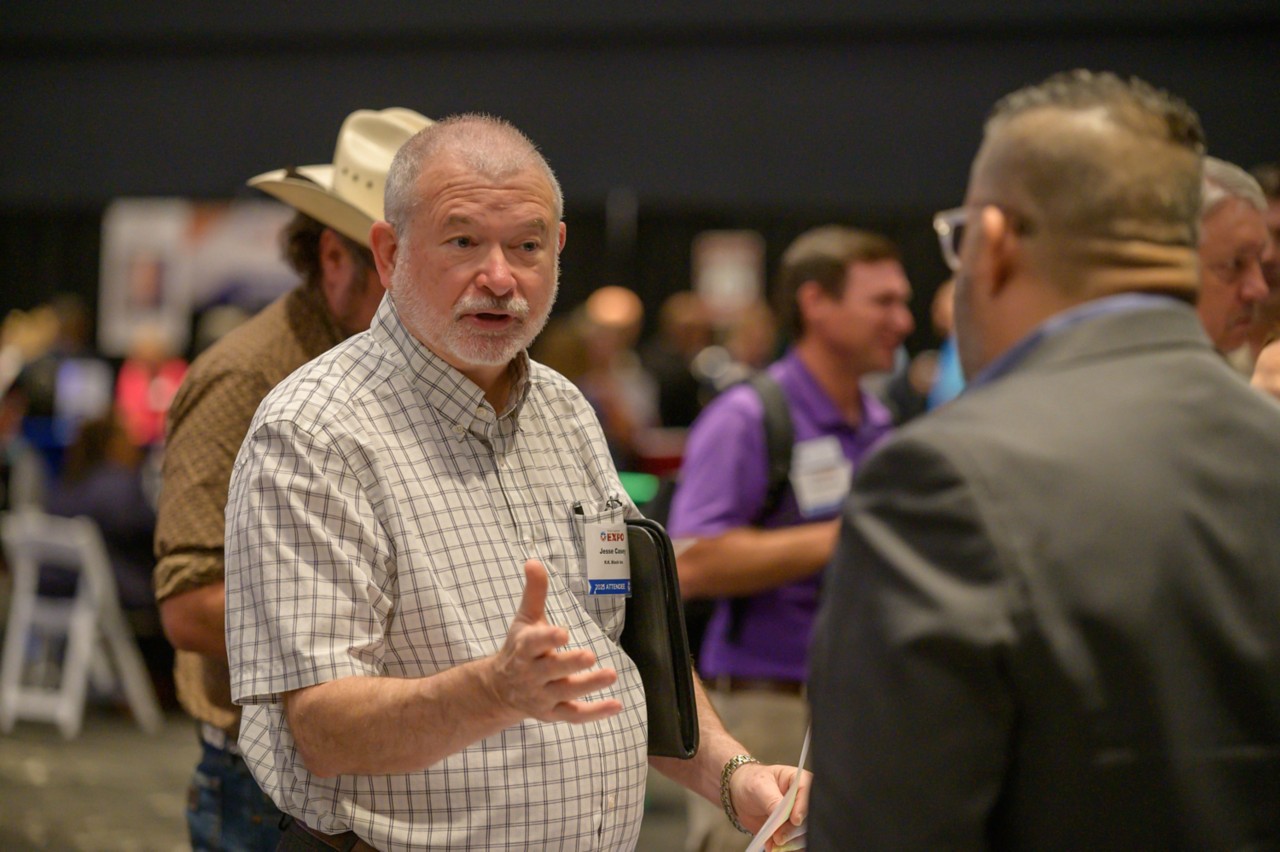 Attendee talking with hands in the ballroom.